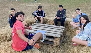 Englischlager the Village: bilingualer Coach spricht mit Teilnehmern Ein bilingualer Coach spricht mit einer Gruppe von Teilnehmern im Englischlager the Village