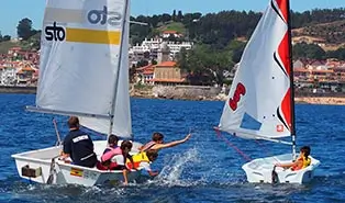 Campamento inglés: experiencia única de vela en inglés Campamento inglés: niños practicando vela en el mar Cantábrico con seguridad.