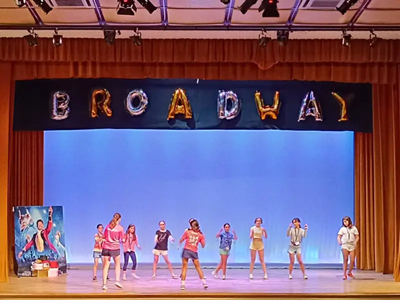 Jóvenes preparan la actuación final de danza y teatro en el campamento de verano en inglés