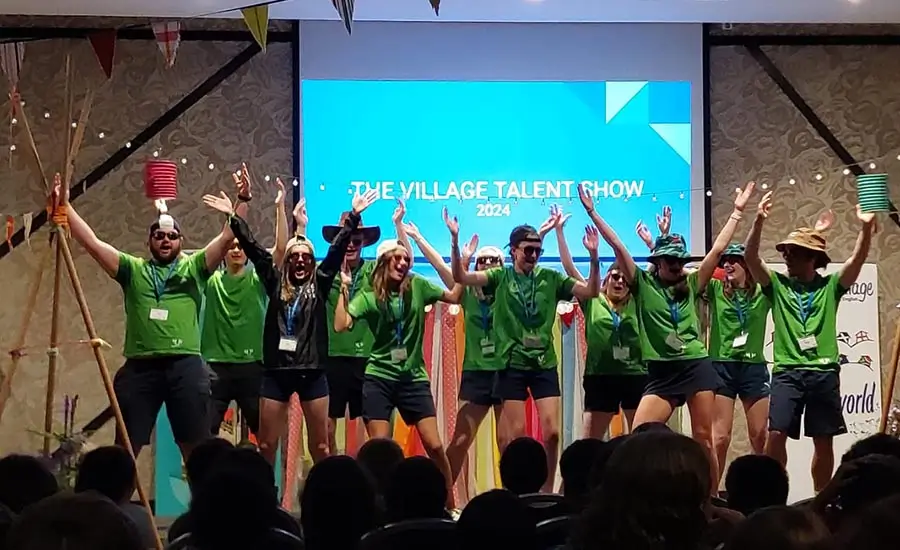 Un grupo de coaches en el campamento de verano en inglés durante una actuación Talent Show en the Village